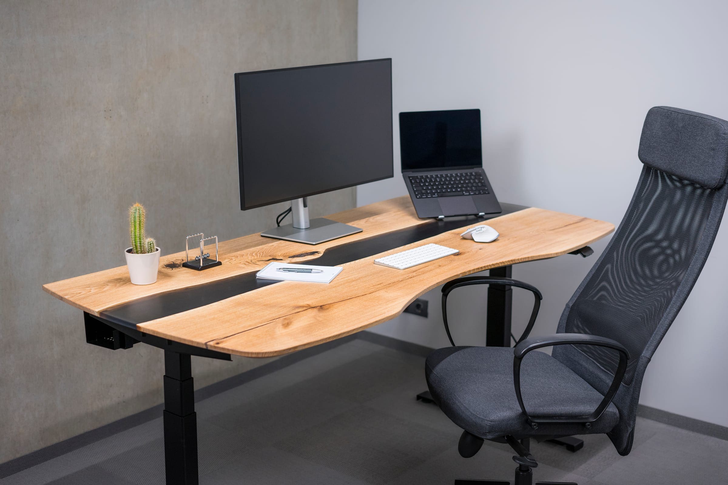 Made-to-order sit-stand desk with an oak slab top and black epoxy river